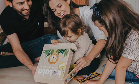 Textbild-Oeffnen-Kolala-Box Familie öffnet Kolala-Box