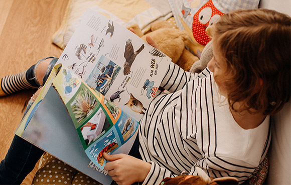 Blogbeitrag-Warum-Kinderzeitschriften-Textbild Brauchen Kinder Zeitschriften Textbild; Kind liest konzentriert