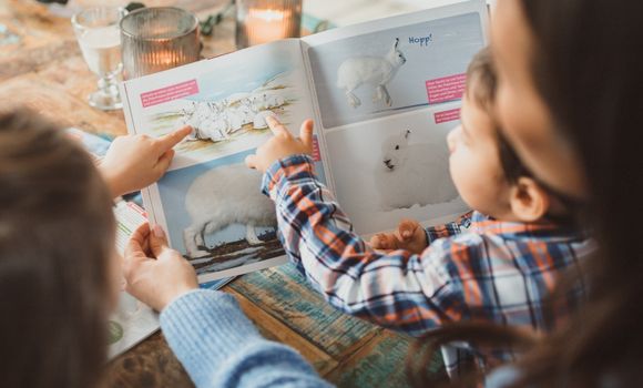 Mutter liest gemeinsam mit Sohn und Tochter Mutter liest gemeinsam mit Sohn und Tochter
