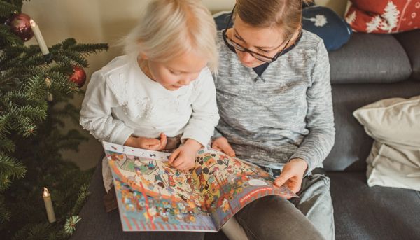 Mutter liest gemeinsam mit ihrer Tochter in einer Zeitschrift Mutter liest gemeinsam mit ihrer Tochter in einer Zeitschrift