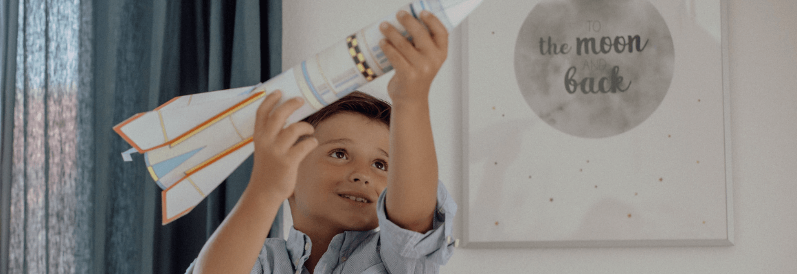 Junge spielt mit einer Papierrakete Junge spielt mit einer Papierrakete